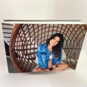 Ampla capa de foto impressa com jovem sorridente em cabana de vime, destaque para qualidade e acabamento do foto livro.