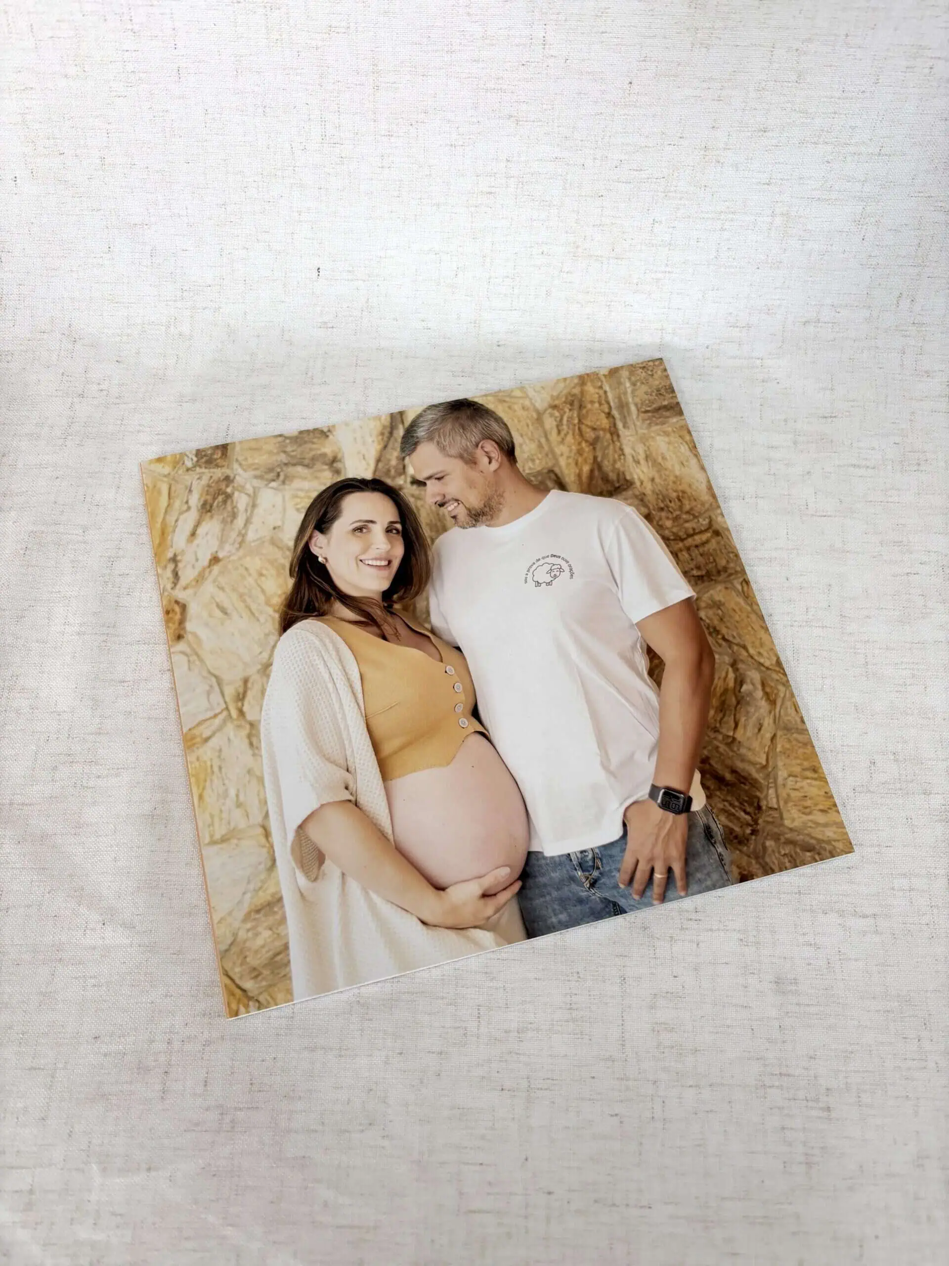 Fotografia de casal grávido sorrindo, com fundo de rochas, comemorando momento especial com Alfafotobook Pro.